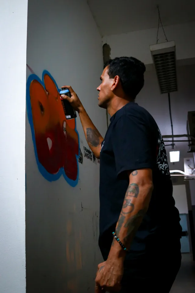 Killa pintando graffiti em uma parede